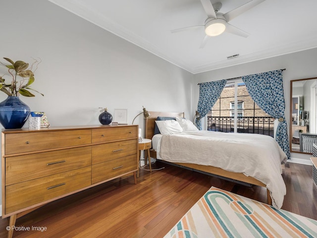 bedroom with dark wood finished floors, ceiling fan, and ornamental molding