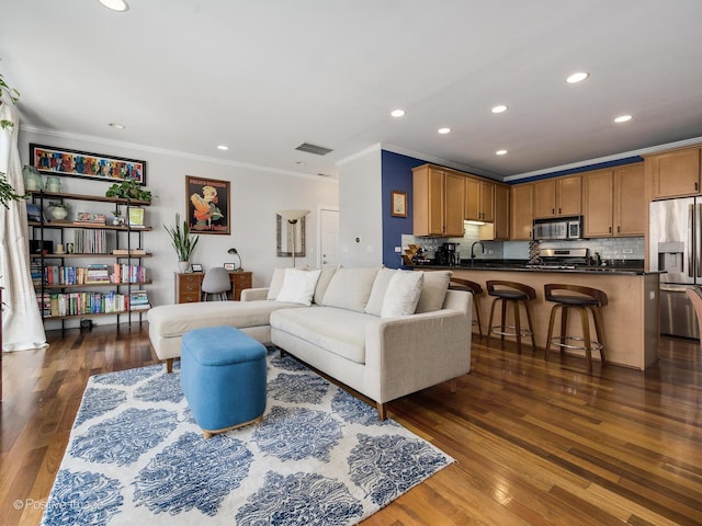 living room featuring dark wood finished floors, crown molding, and recessed lighting