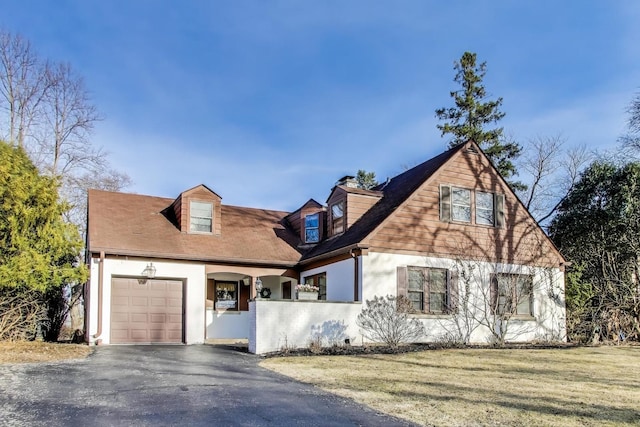 view of front facade featuring a front lawn, an attached garage, driveway, and stucco siding