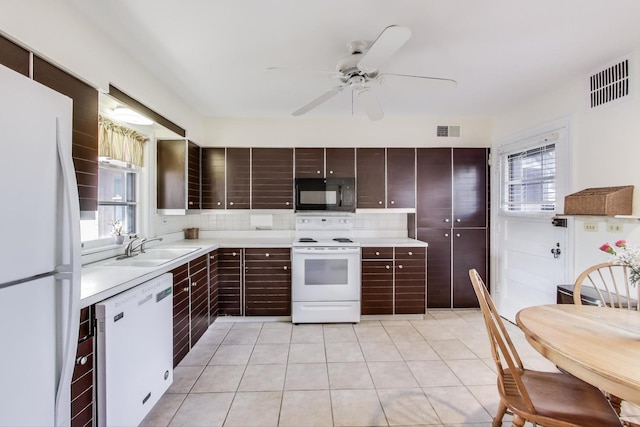 kitchen featuring white appliances, light countertops, visible vents, and a sink