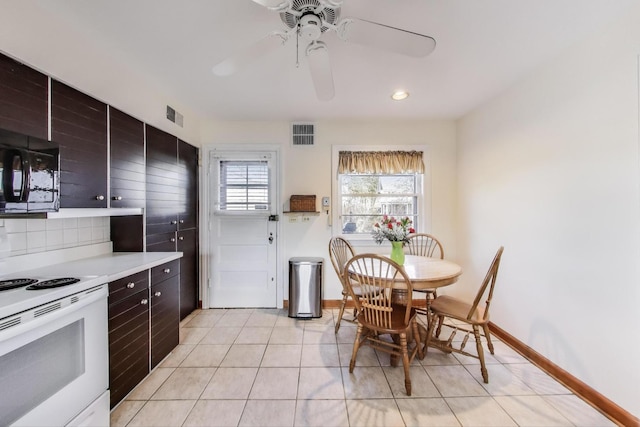 kitchen featuring visible vents, white range with electric stovetop, black microwave, light countertops, and light tile patterned floors