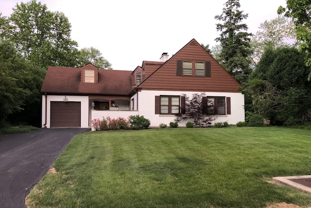 view of front of property featuring aphalt driveway, an attached garage, and a front lawn