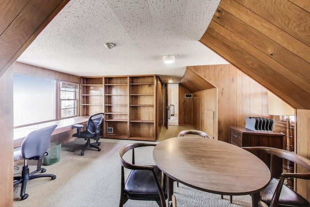 office with wooden walls, built in shelves, a textured ceiling, and carpet floors