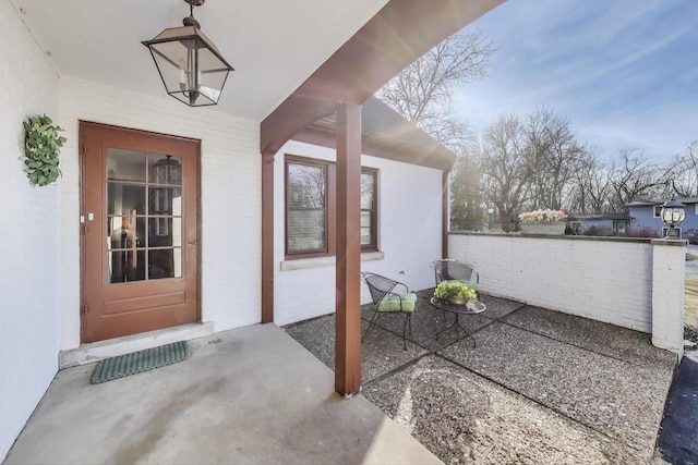 entrance to property featuring brick siding and a patio area