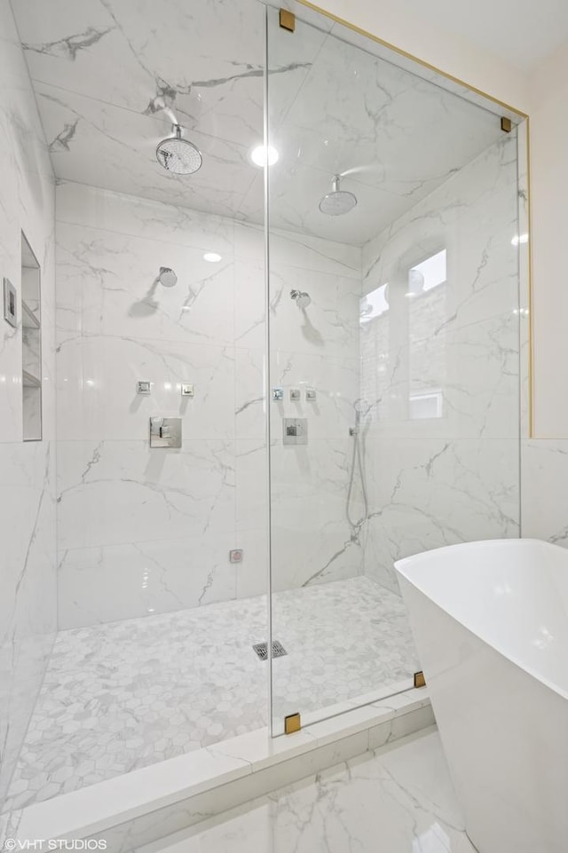 full bathroom with a marble finish shower, a freestanding bath, and marble finish floor