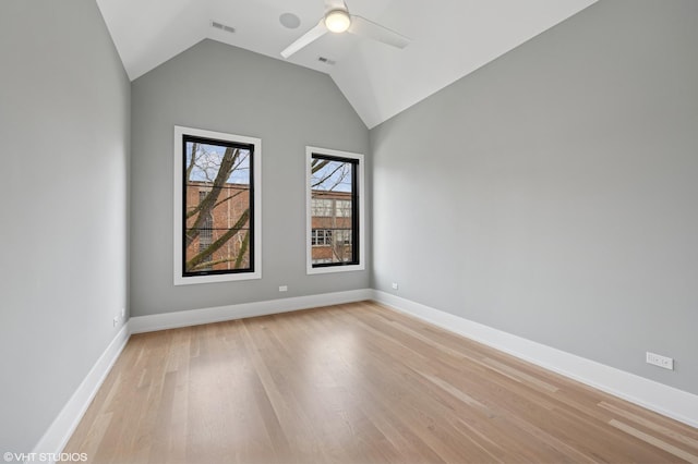 spare room with visible vents, ceiling fan, baseboards, vaulted ceiling, and light wood-style floors