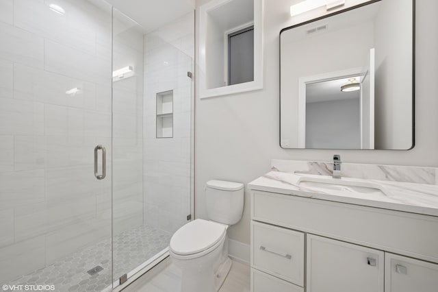 bathroom featuring visible vents, toilet, a stall shower, and vanity