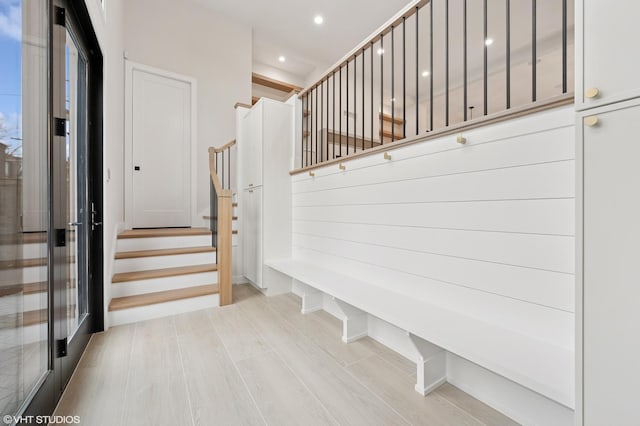 stairway with recessed lighting and wood finished floors