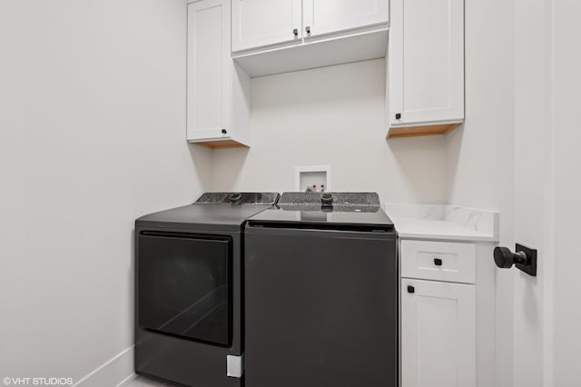 washroom featuring cabinet space, washer and dryer, and baseboards