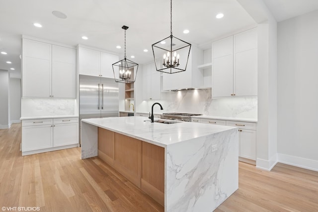 kitchen with open shelves, light wood-type flooring, white cabinets, and a sink