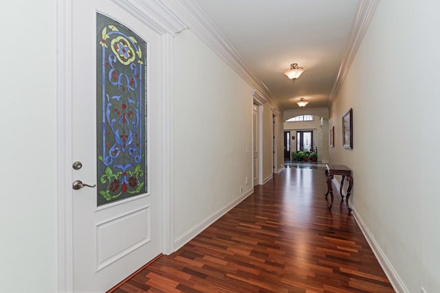 hall with arched walkways, dark wood finished floors, baseboards, and ornamental molding