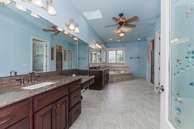 full bath with a skylight, a bath, a ceiling fan, and a sink