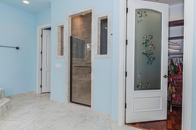 full bath featuring a walk in closet and a stall shower