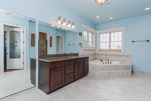 full bath featuring vanity, a garden tub, and recessed lighting