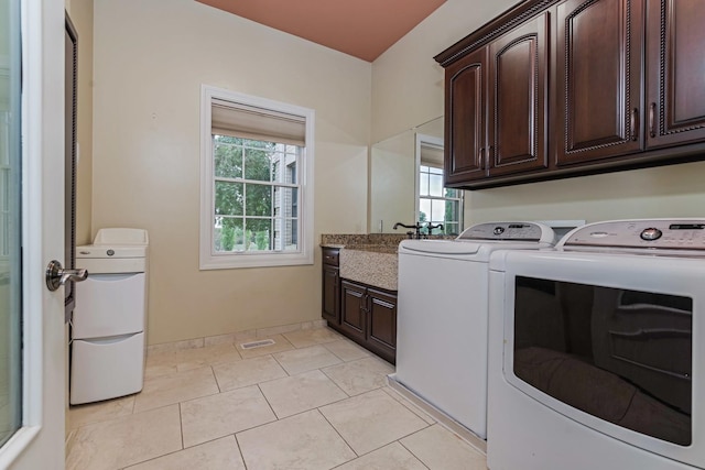 clothes washing area featuring visible vents, washer and clothes dryer, light tile patterned floors, cabinet space, and a sink