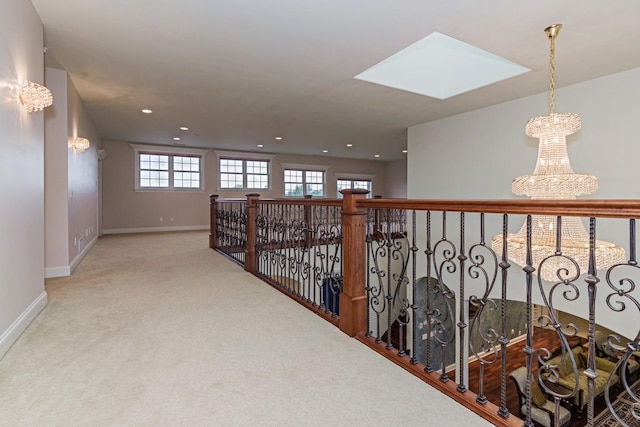 hall with recessed lighting, baseboards, a skylight, and carpet flooring