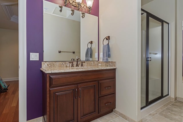 full bathroom with baseboards, a stall shower, and vanity