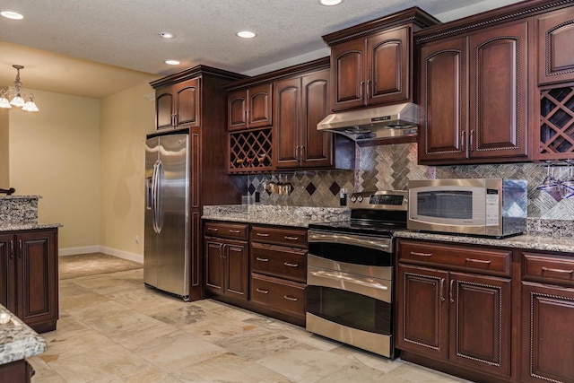 kitchen with under cabinet range hood, backsplash, baseboards, and appliances with stainless steel finishes