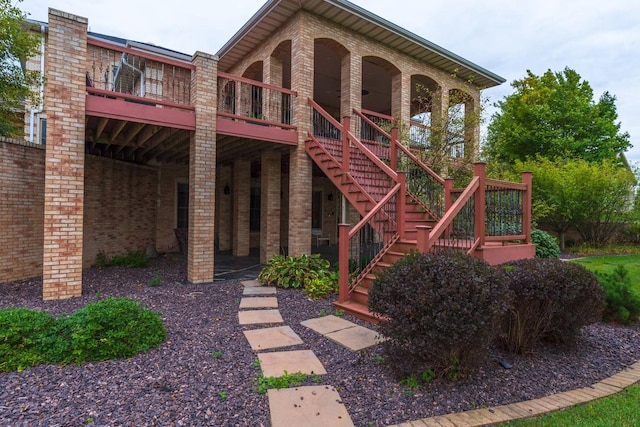 exterior space featuring brick siding and stairs