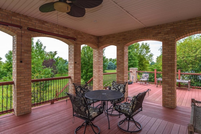 wooden deck featuring outdoor dining space and ceiling fan