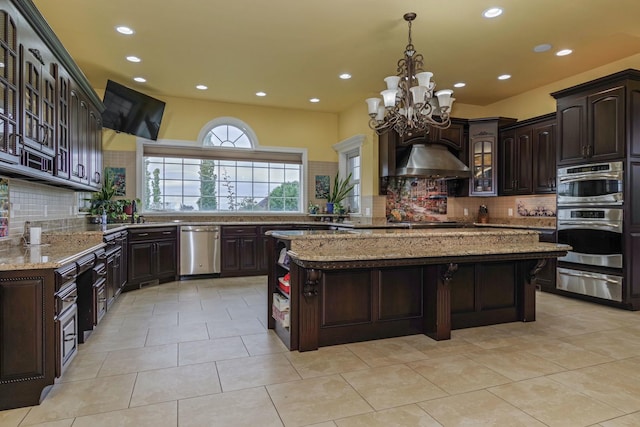 kitchen featuring dark brown cabinetry, a warming drawer, light stone counters, and appliances with stainless steel finishes