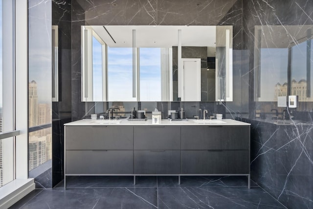 bathroom featuring double vanity, marble finish floor, and a sink