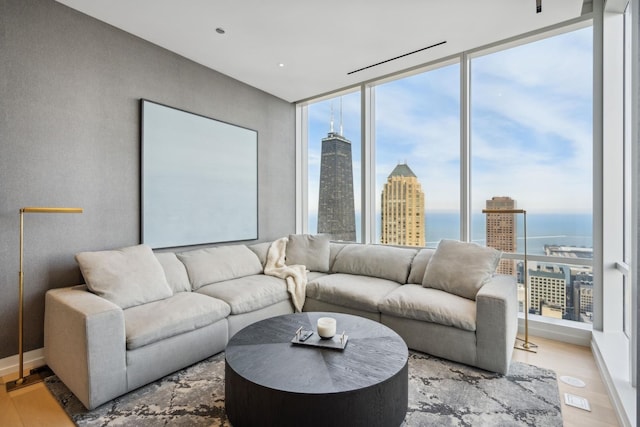 living room with a view of city, plenty of natural light, and wood finished floors