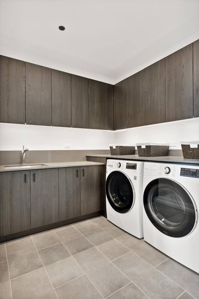 laundry room featuring light tile patterned floors, cabinet space, independent washer and dryer, and a sink