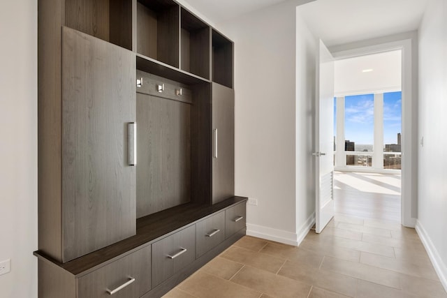 mudroom featuring baseboards and light tile patterned flooring