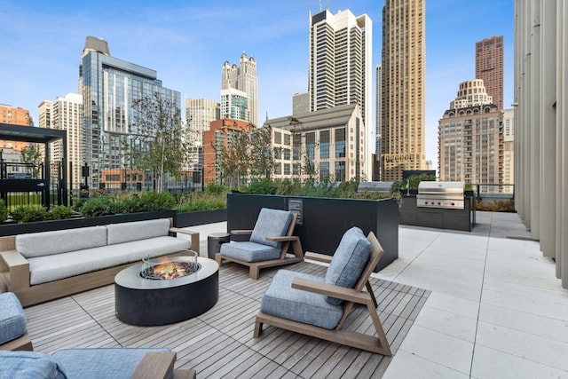 view of patio featuring an outdoor living space with a fire pit, area for grilling, a view of city, and a grill