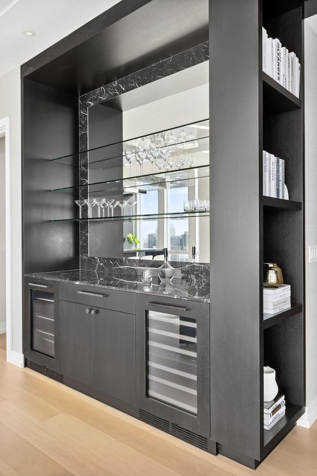 bar with wine cooler, indoor wet bar, and wood finished floors