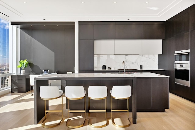 kitchen with expansive windows, tasteful backsplash, modern cabinets, and a healthy amount of sunlight