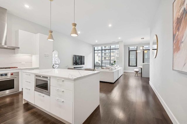 kitchen with dark wood finished floors, modern cabinets, wall chimney exhaust hood, and stainless steel oven