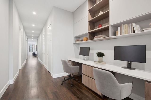 home office with recessed lighting, baseboards, dark wood-type flooring, and built in desk