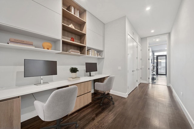 home office with recessed lighting, baseboards, dark wood-type flooring, and built in desk