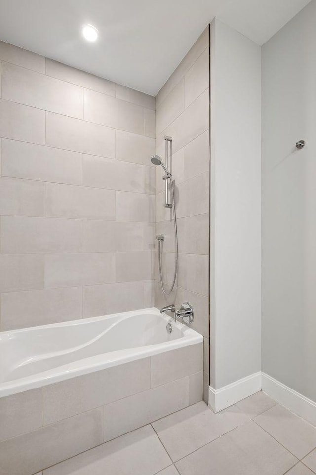 bathroom featuring tile patterned floors, tiled shower / bath, and baseboards