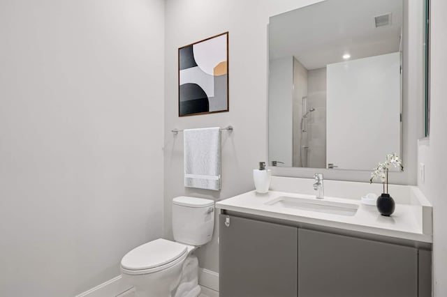 full bath featuring visible vents, toilet, baseboards, walk in shower, and vanity