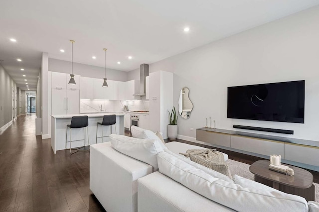 living area with recessed lighting, dark wood-style flooring, and baseboards