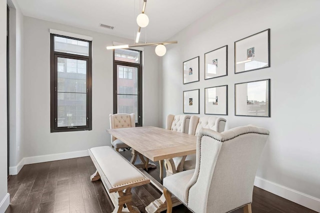 dining room featuring baseboards, visible vents, and dark wood-style flooring