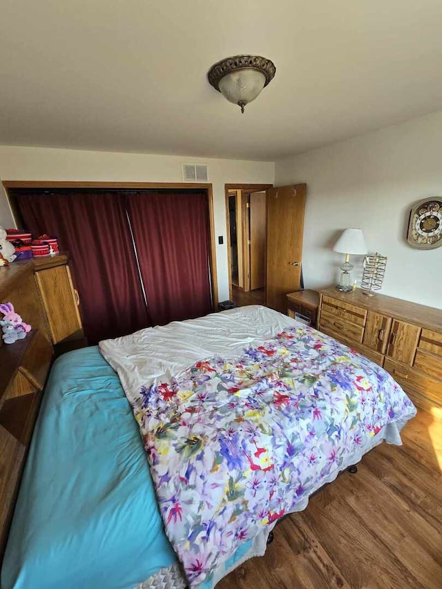 bedroom featuring visible vents and wood finished floors