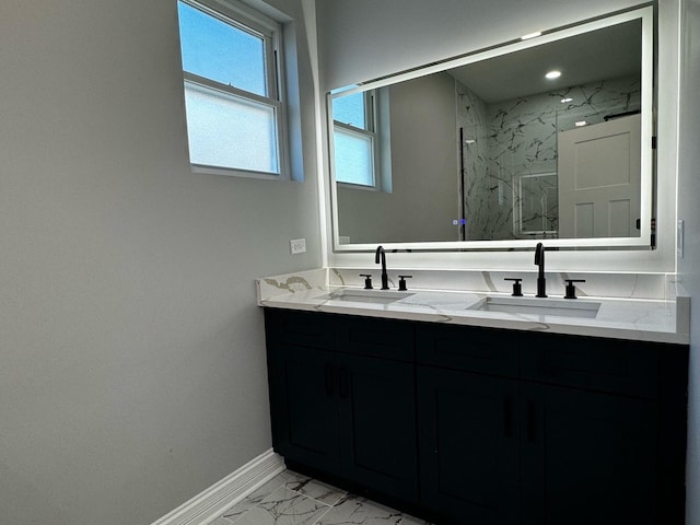 bathroom featuring double vanity, marble finish floor, a marble finish shower, and a sink