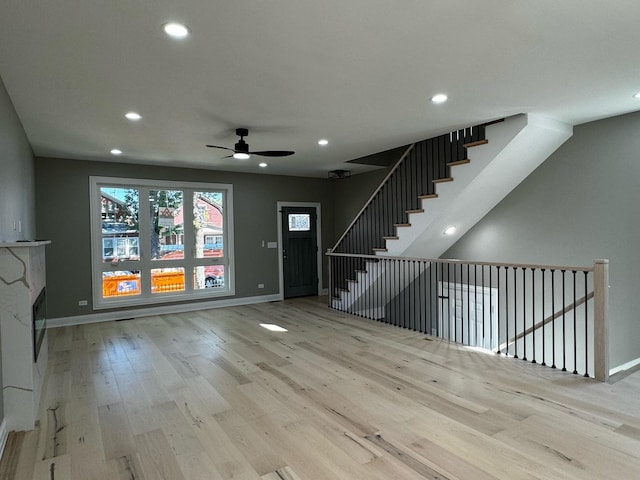 unfurnished living room with stairway, recessed lighting, baseboards, and wood finished floors