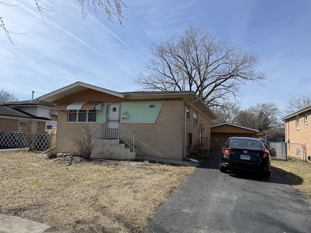 bungalow-style house with brick siding and fence