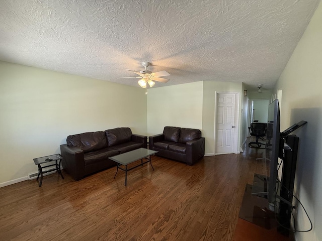 living area featuring a textured ceiling, dark wood-style flooring, and ceiling fan