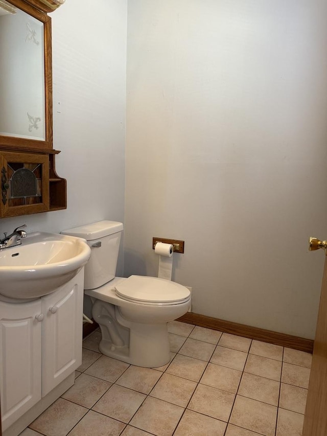 bathroom with tile patterned flooring, toilet, vanity, and baseboards