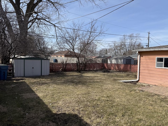 view of yard featuring a storage unit, an outdoor structure, and fence