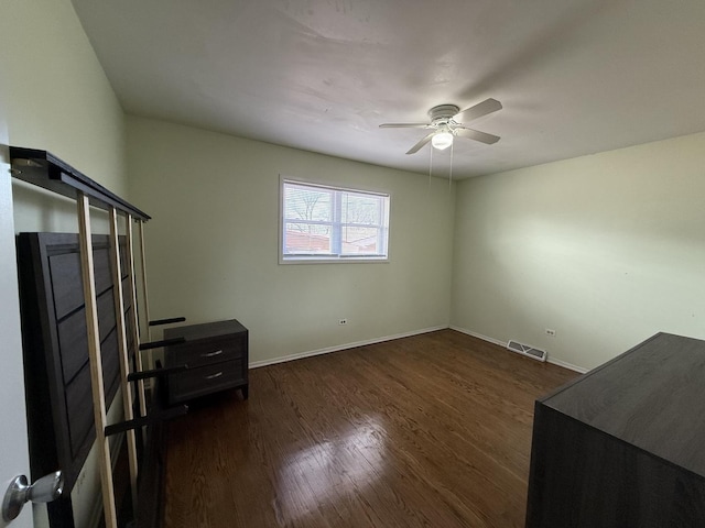 bedroom with ceiling fan, visible vents, baseboards, and dark wood finished floors