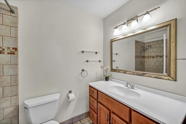 full bath featuring tiled shower, toilet, vanity, and tile patterned flooring