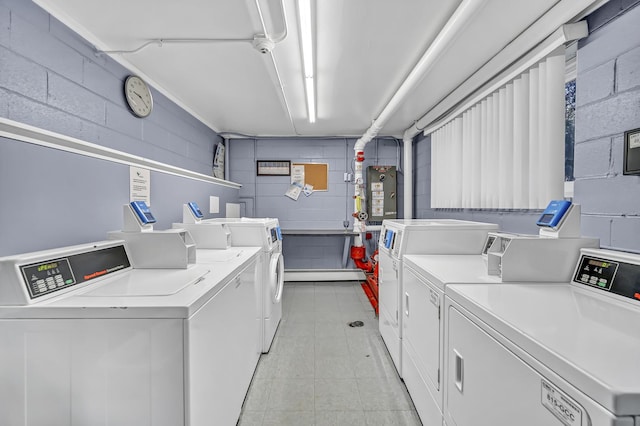 shared laundry area with concrete block wall and washing machine and clothes dryer