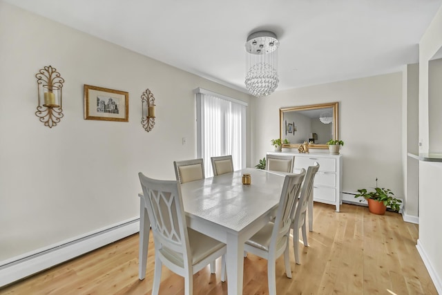 dining room featuring a baseboard radiator, an inviting chandelier, and light wood-style flooring